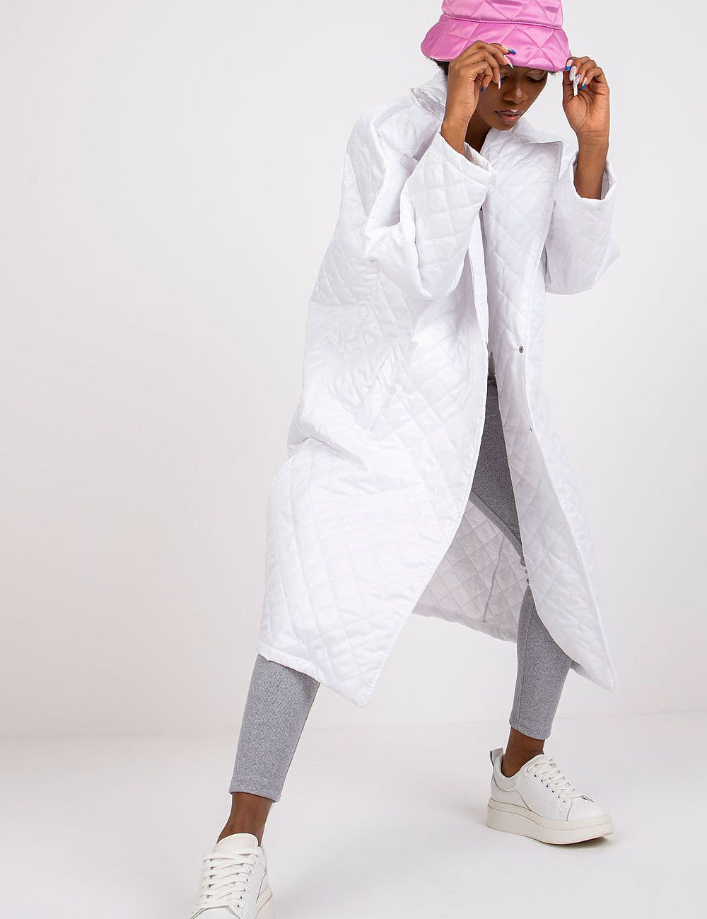 Model wearing white Orlianne Quilted Transitional Coat with pink hat, showcasing lightweight, chic design for urban layering.
