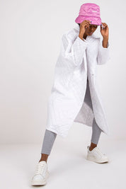 Model wearing white Orlianne Quilted Transitional Coat with pink hat, showcasing lightweight, chic design for urban layering.