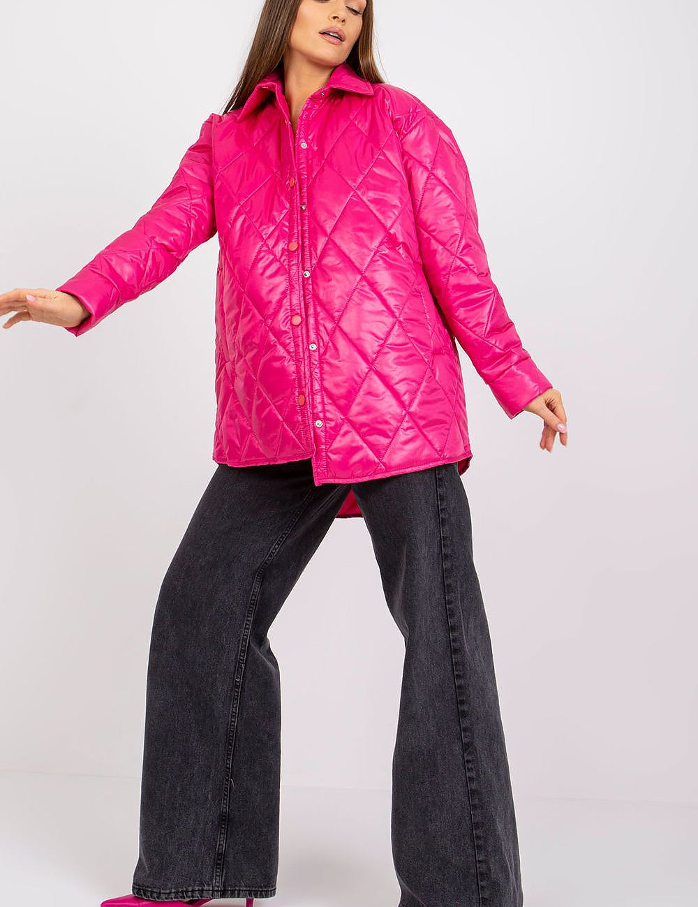 Woman wearing pink Cerenya quilted jacket with extended back, featuring press-stud front and side slip pockets, styled with black pants.