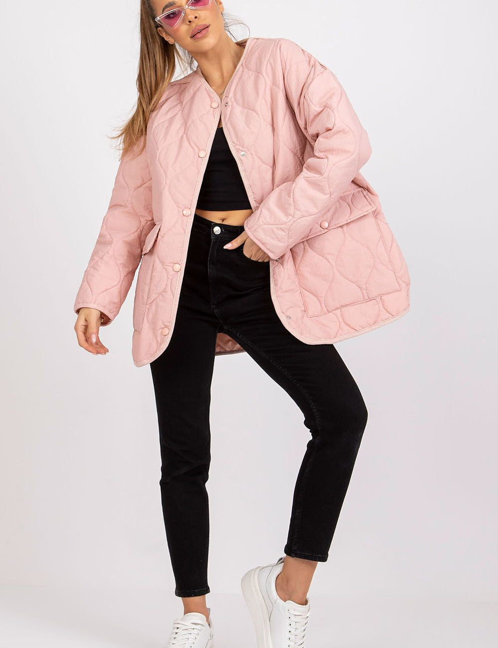 Model wearing Elenique pink quilted jacket with press studs, long sleeves, and spacious pockets, styled with black pants and white sneakers.