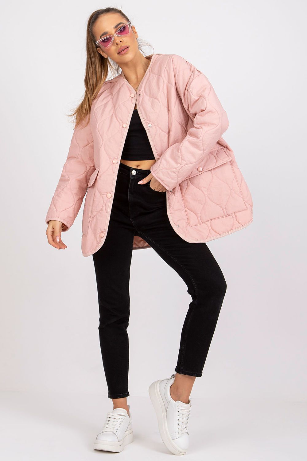 Model wearing Elenique pink quilted jacket with press studs, long sleeves, and spacious pockets, styled with black pants and white sneakers.