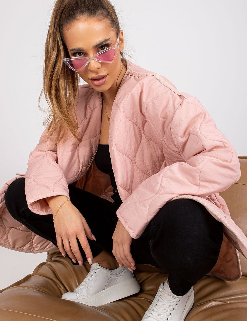 Model wearing Elenique pink quilted jacket with press studs and sunglasses, styled for transitional weather.