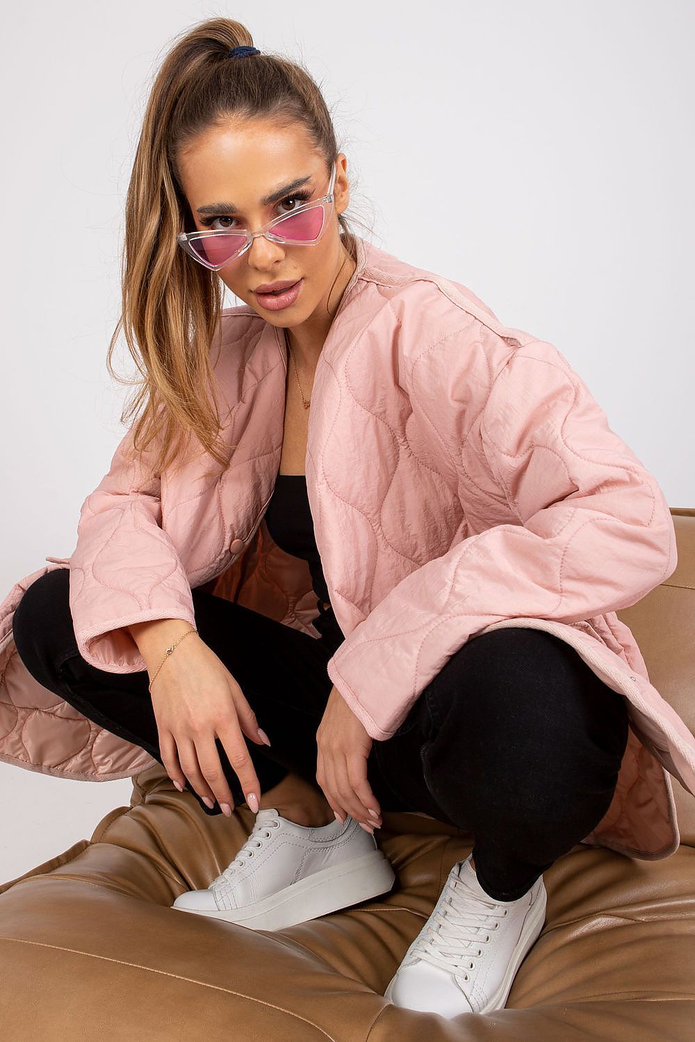 Model wearing Elenique pink quilted jacket with press studs and sunglasses, styled for transitional weather.