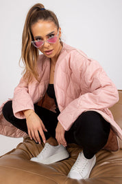 Model wearing Elenique pink quilted jacket with press studs and sunglasses, styled for transitional weather.
