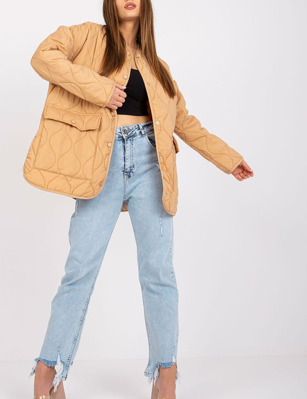 Model wearing Elenique lightweight quilted jacket with press studs, paired with distressed jeans and clear high heels.