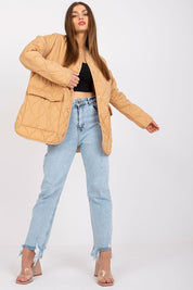 Model wearing Elenique lightweight quilted jacket with press studs, paired with distressed jeans and clear high heels.