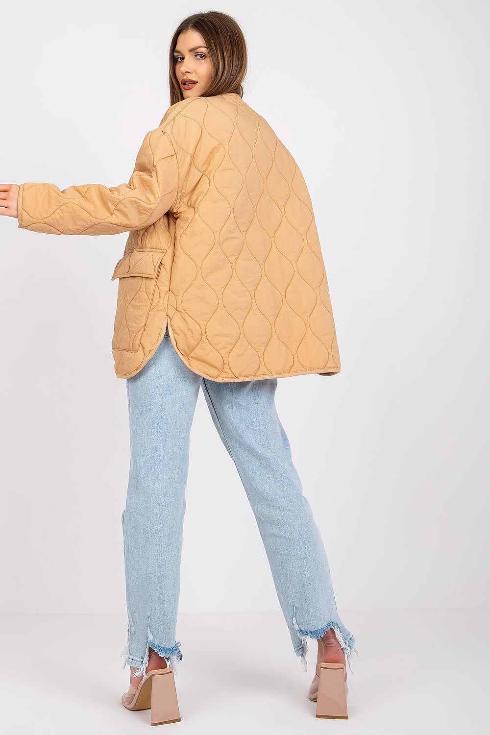 Woman wearing Elenique quilted jacket with press studs, showcasing long sleeves and practical pockets for transitional weather elegance.