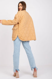 Woman wearing Elenique quilted jacket with press studs, showcasing long sleeves and practical pockets for transitional weather elegance.