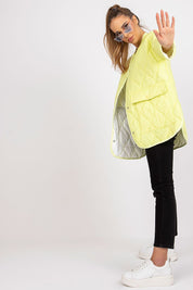 Model wearing Elenique lightweight quilted jacket with press studs, front view, styled with black pants and white sneakers, casual look.