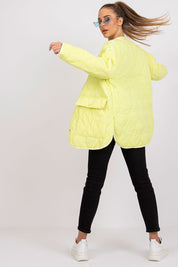 Woman wearing Elenique quilted jacket with press studs, showcasing a stylish transitional outerwear piece in yellow.