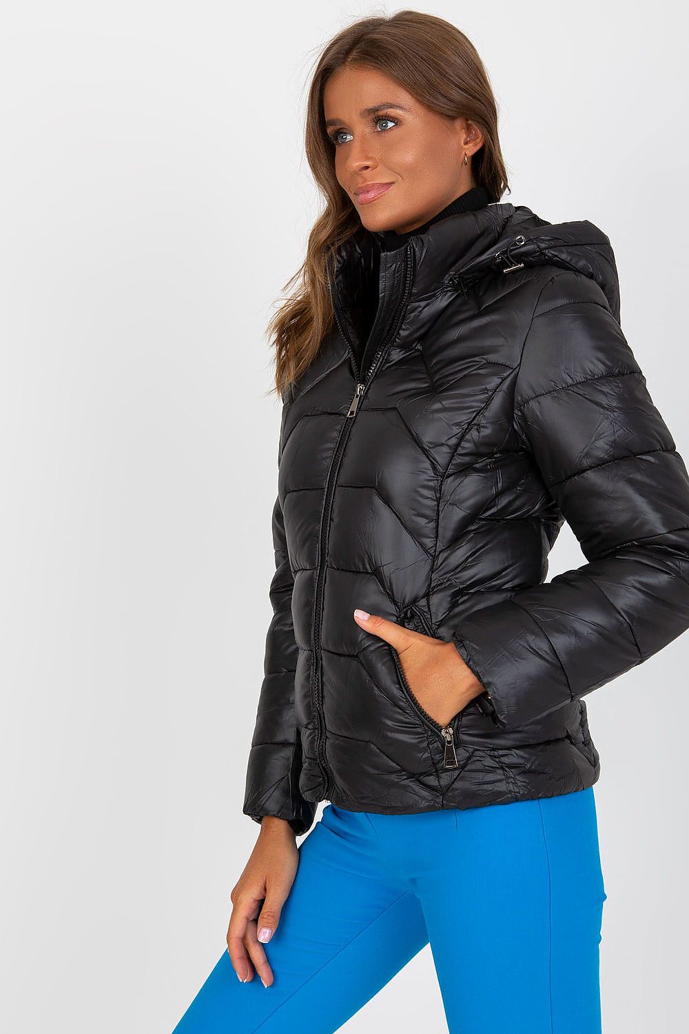 Woman wearing a black Evelora quilted gilet with detachable hood, showcasing elegant design with comfort and practicality for cool days.