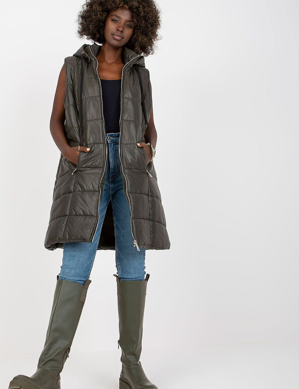 Model wearing Evrendelle Quilted Longline Vest with detachable hood, demonstrating sleek silhouette and practical zippered pockets.