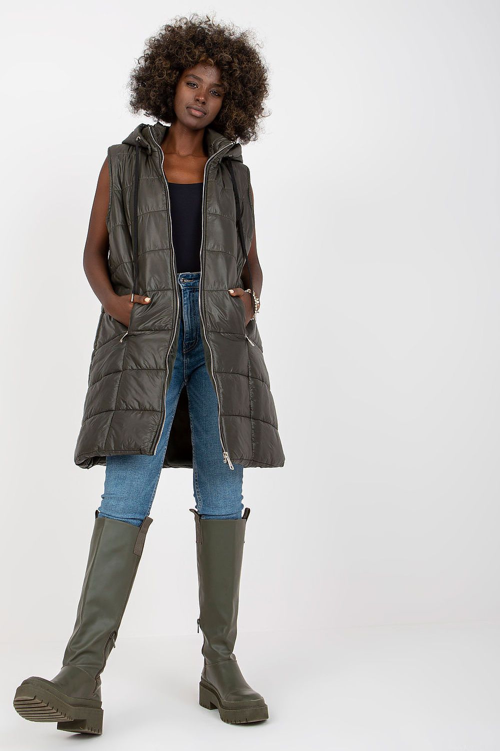 Model wearing Evrendelle Quilted Longline Vest with detachable hood, demonstrating sleek silhouette and practical zippered pockets.