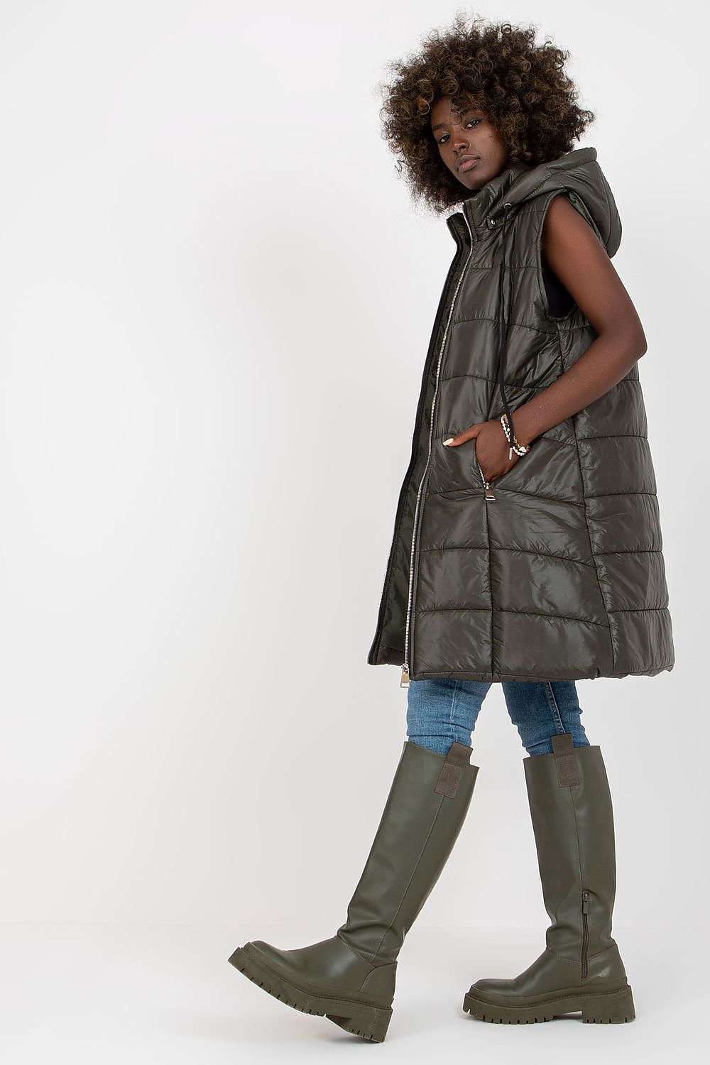 Woman wearing Evrendelle Quilted Longline Vest with detachable hood, showcasing sleek silhouette and practicality for transitional seasons.
