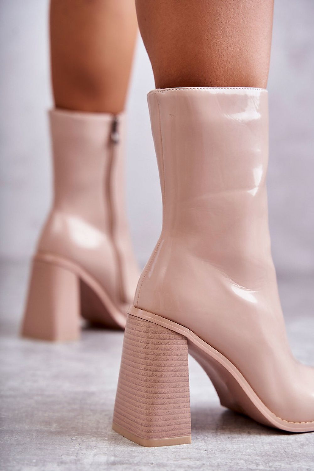 Glossy mid-calf boots with lacquered finish and block heels in nude, featuring side zipper and eco-leather design for style and comfort.