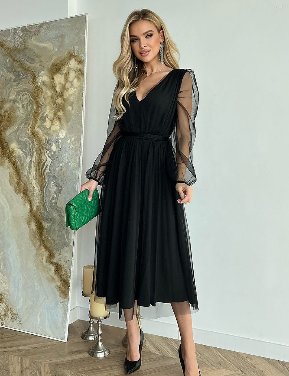 Woman wearing Marleia Mesh-Layered Evening Midi Dress with sheer sleeves and carrying a green bag.