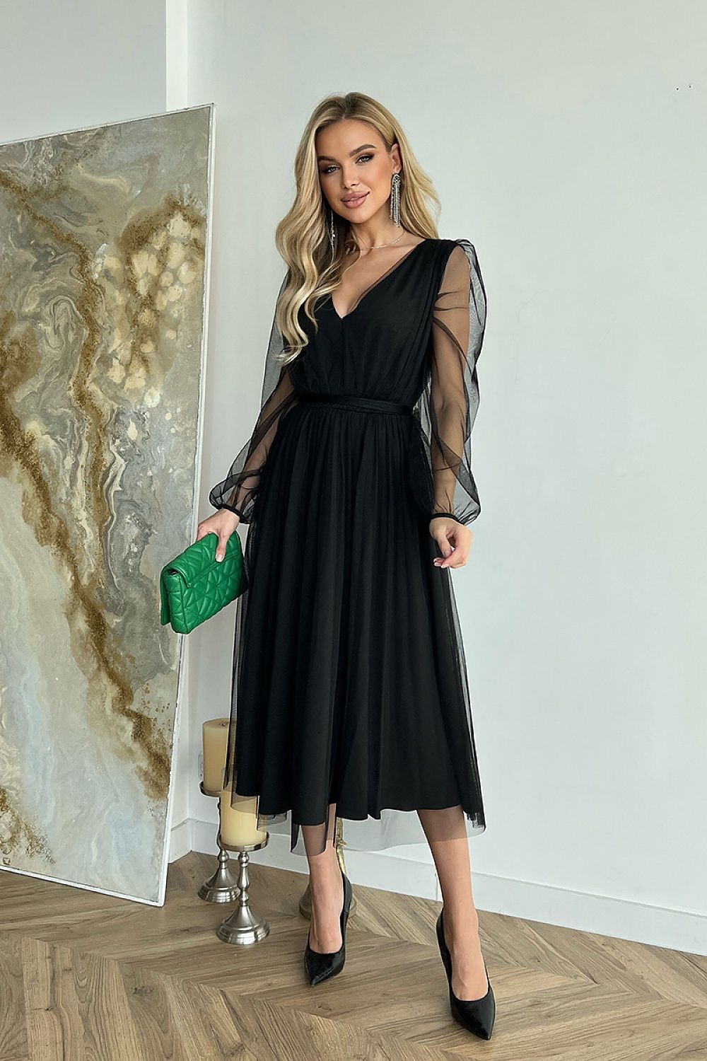 Woman wearing Marleia Mesh-Layered Evening Midi Dress with sheer sleeves and carrying a green bag.