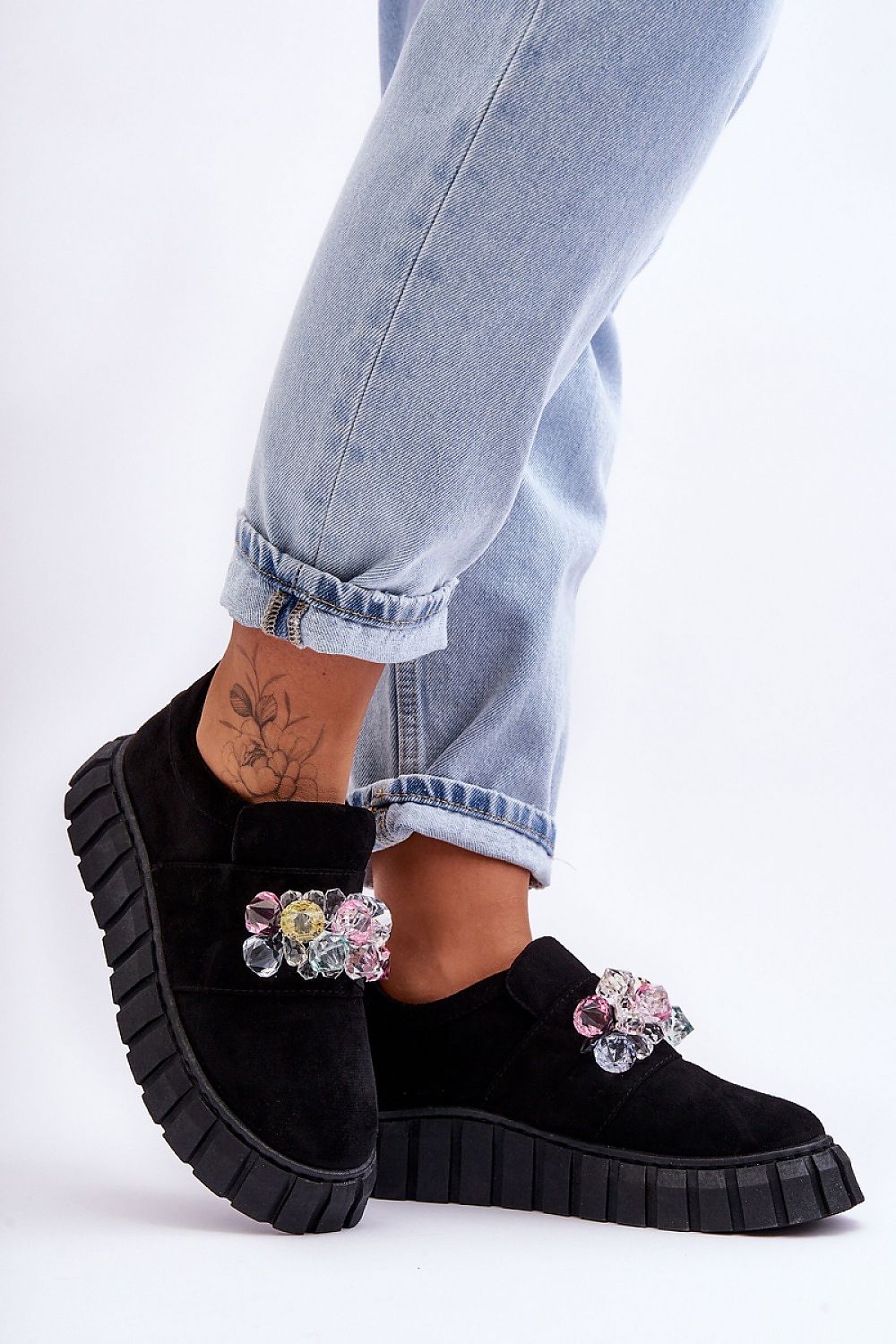 Woman wearing Verelune Crystal Platform Slip-Ons with eco-suede texture and sparkling crystal accents, showcasing chic, comfortable style.