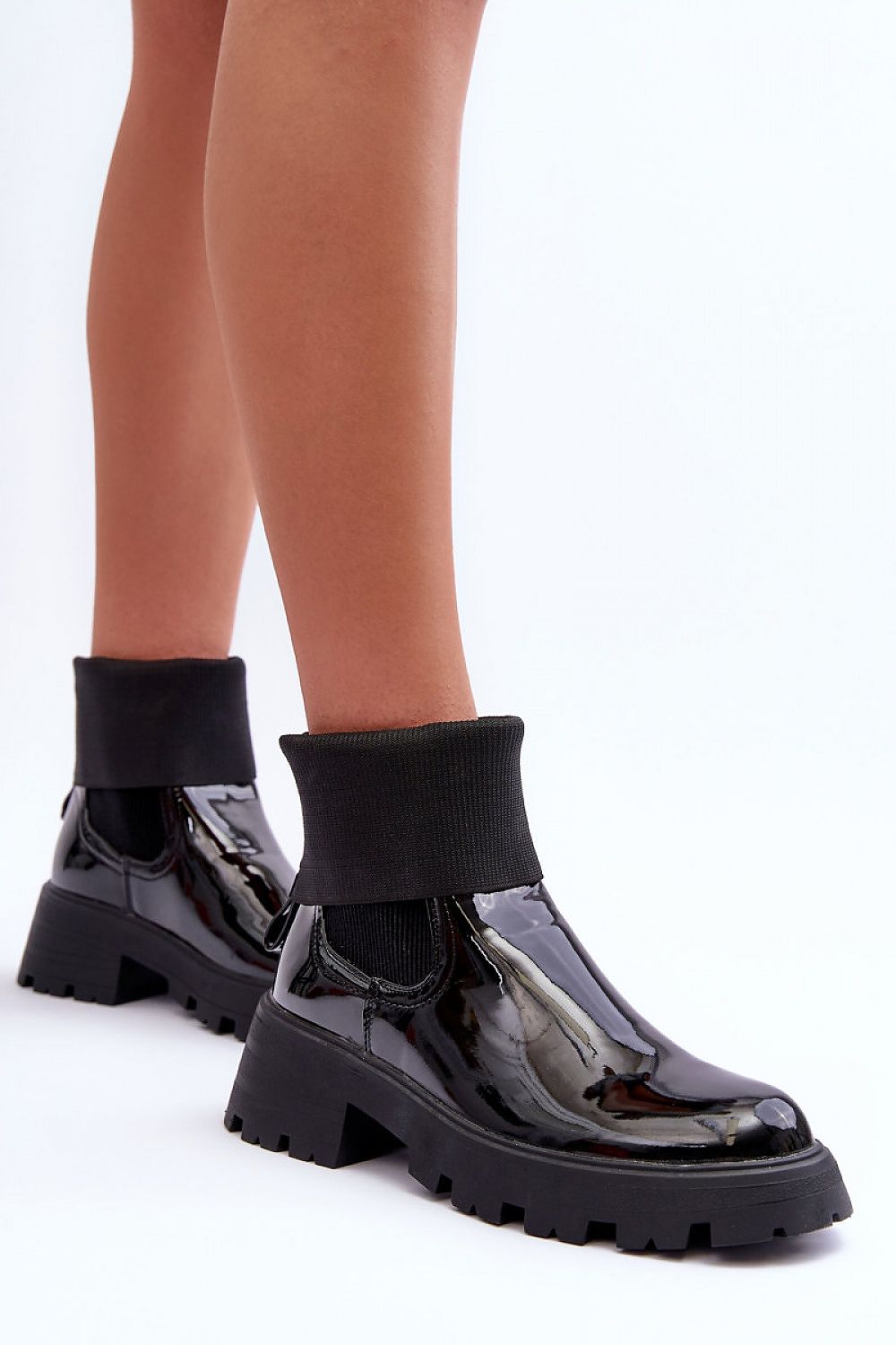 Woman wearing Arminne Chunky Ankle Boots in black eco leather with elastic inserts, thick platform, and block heel for stylish city looks.