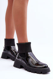 Woman wearing Arminne Chunky Ankle Boots in black eco leather with elastic inserts, thick platform, and block heel for stylish city looks.