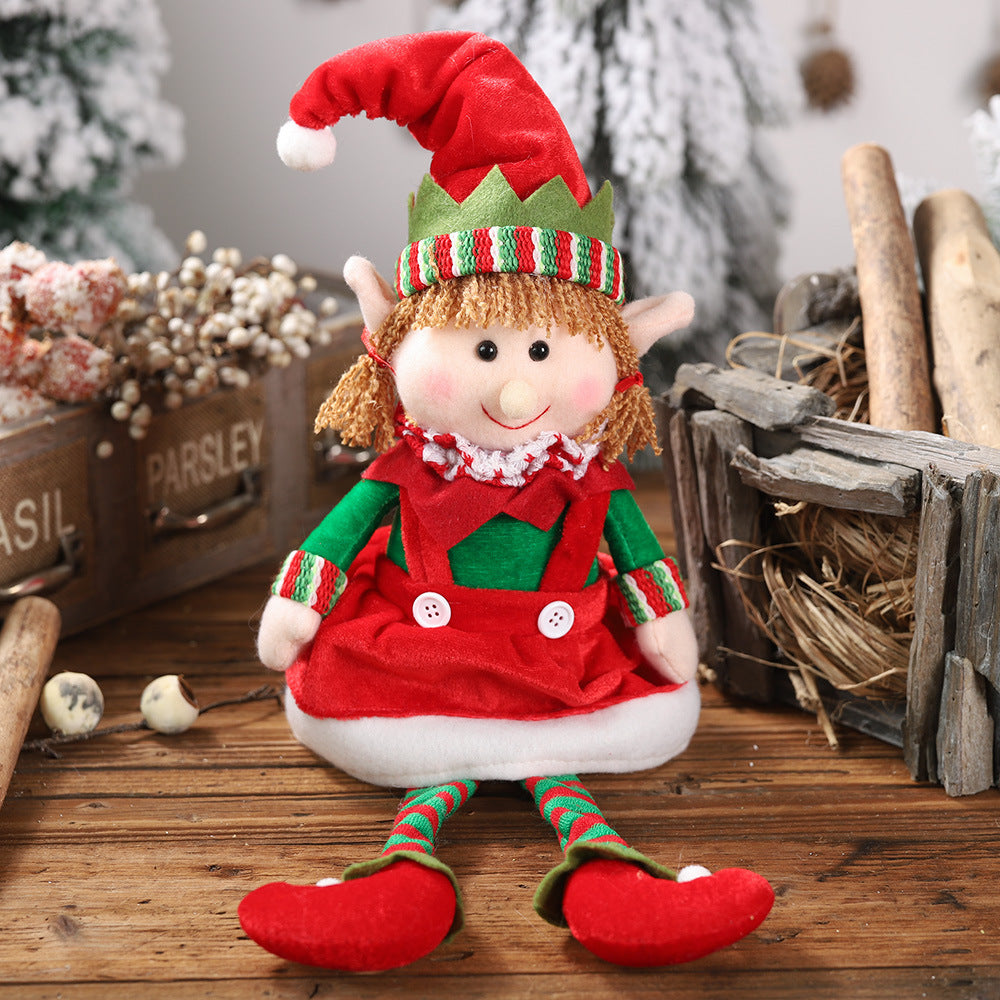 Festive female Christmas doll ornament with red and green outfit, sitting with hanging legs, perfect for holiday home decoration.