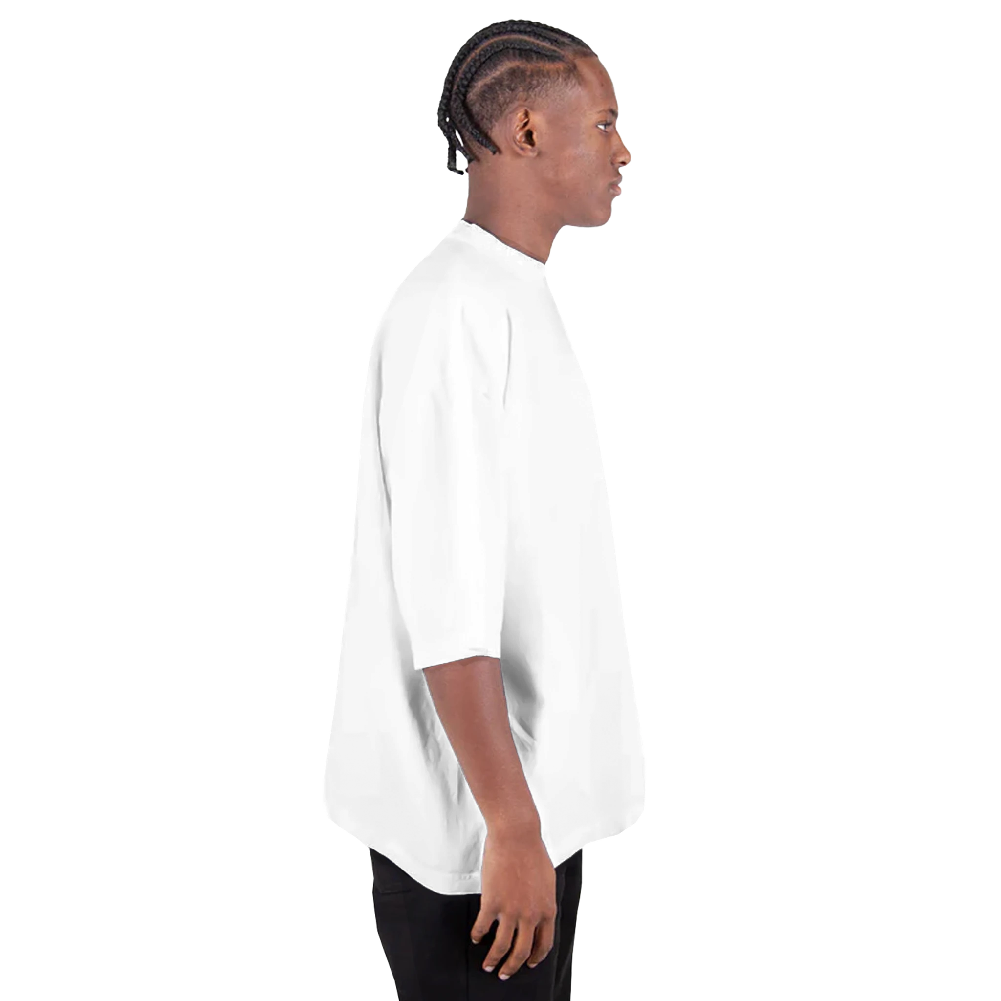 Side view of a man wearing a Shaka Wear oversized drop-shoulder crewneck t-shirt in white, showcasing its relaxed fit and streetwear style.