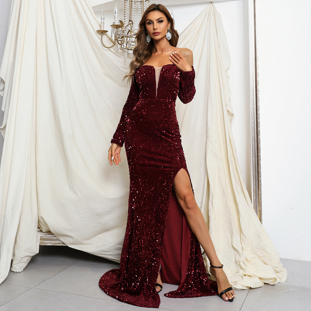 Woman wearing a deep burgundy Talvinea off-shoulder sequin gown with thigh-high slit, standing in an elegant setting.