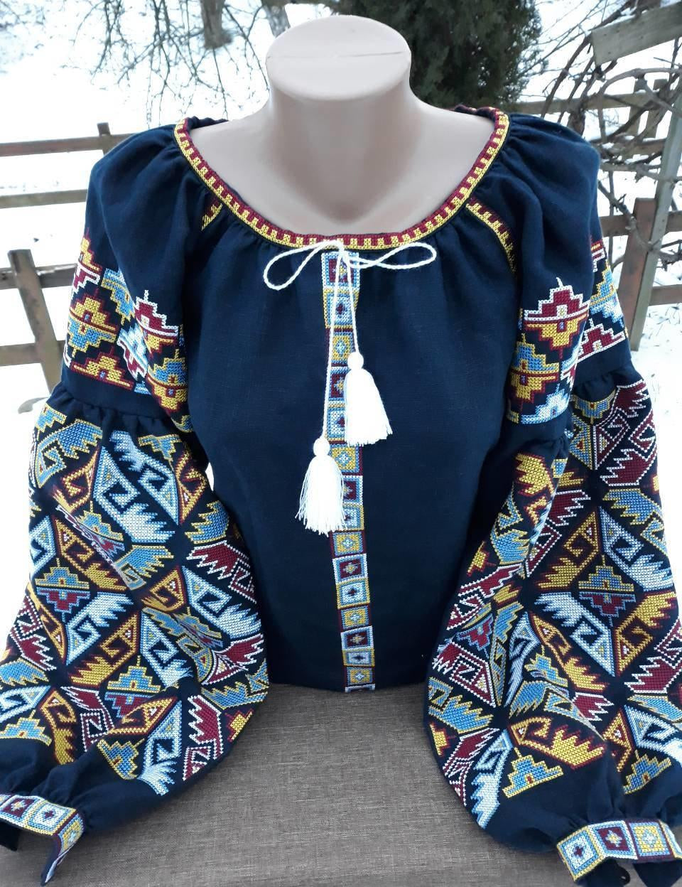 Dark blue Ukrainian embroidered blouse with folk motifs and silk thread cross-stitch, featuring long patterned sleeves.