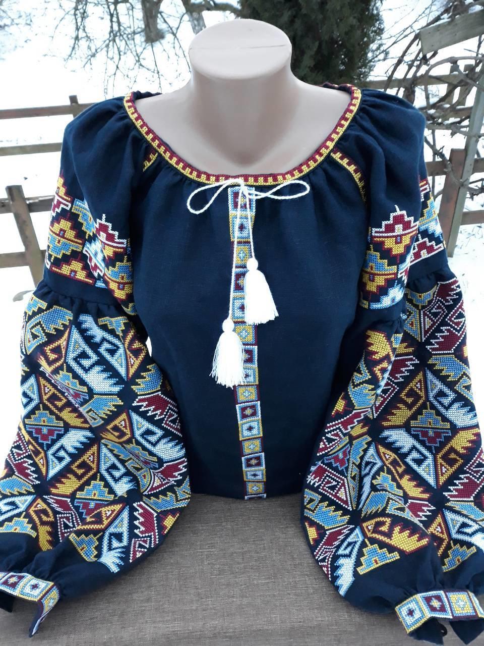 Dark blue Ukrainian embroidered blouse with folk motifs and silk thread cross-stitch, featuring long patterned sleeves.