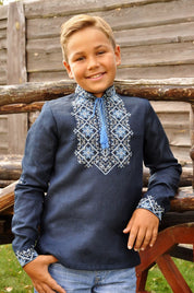 Boy wearing dark blue Ukrainian embroidered linen shirt with Alatyr symbol