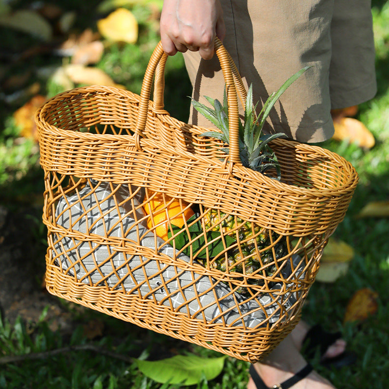 Handmade rattan-like picnic basket filled with fruits, perfect for stylish outings and shopping. Durable plastic woven design in brown.