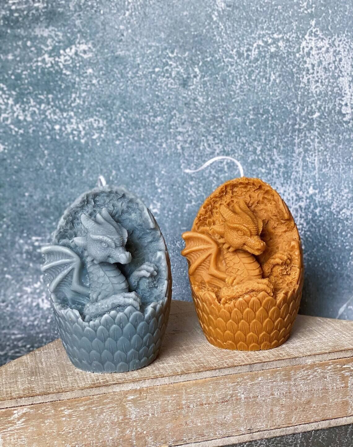 Two handmade dragon's egg candles in blue and orange hues, crafted from natural soy wax, adding mythical charm and warmth to any space.
