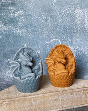 Two handmade dragon's egg candles in blue and orange hues, crafted from natural soy wax, adding mythical charm and warmth to any space.