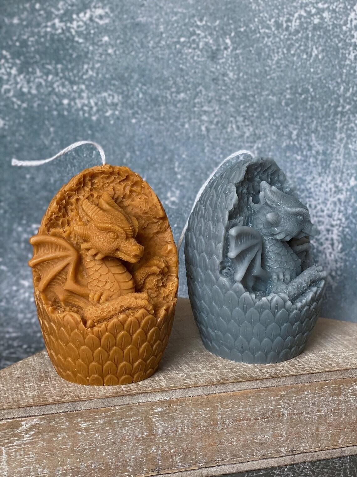 Handmade dragon's egg candles, crafted from natural soy wax in various colors, resting on wooden surface.