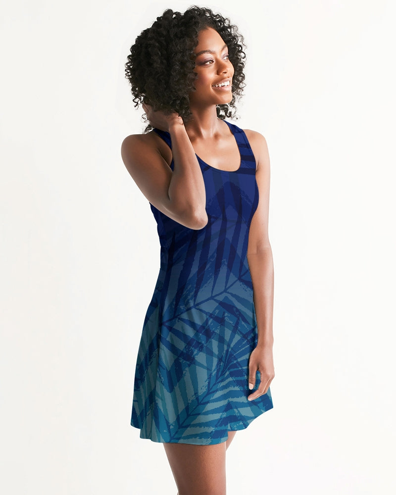 Woman wearing Sunset Hour Racerback Dress with tropical print, showcasing relaxed charm and carefree vibe. Perfect for sunny strolls.