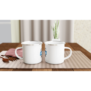 Two 12oz white enamel mugs with silver rims on a plaid tablecloth, perfect for camping or custom artwork display.