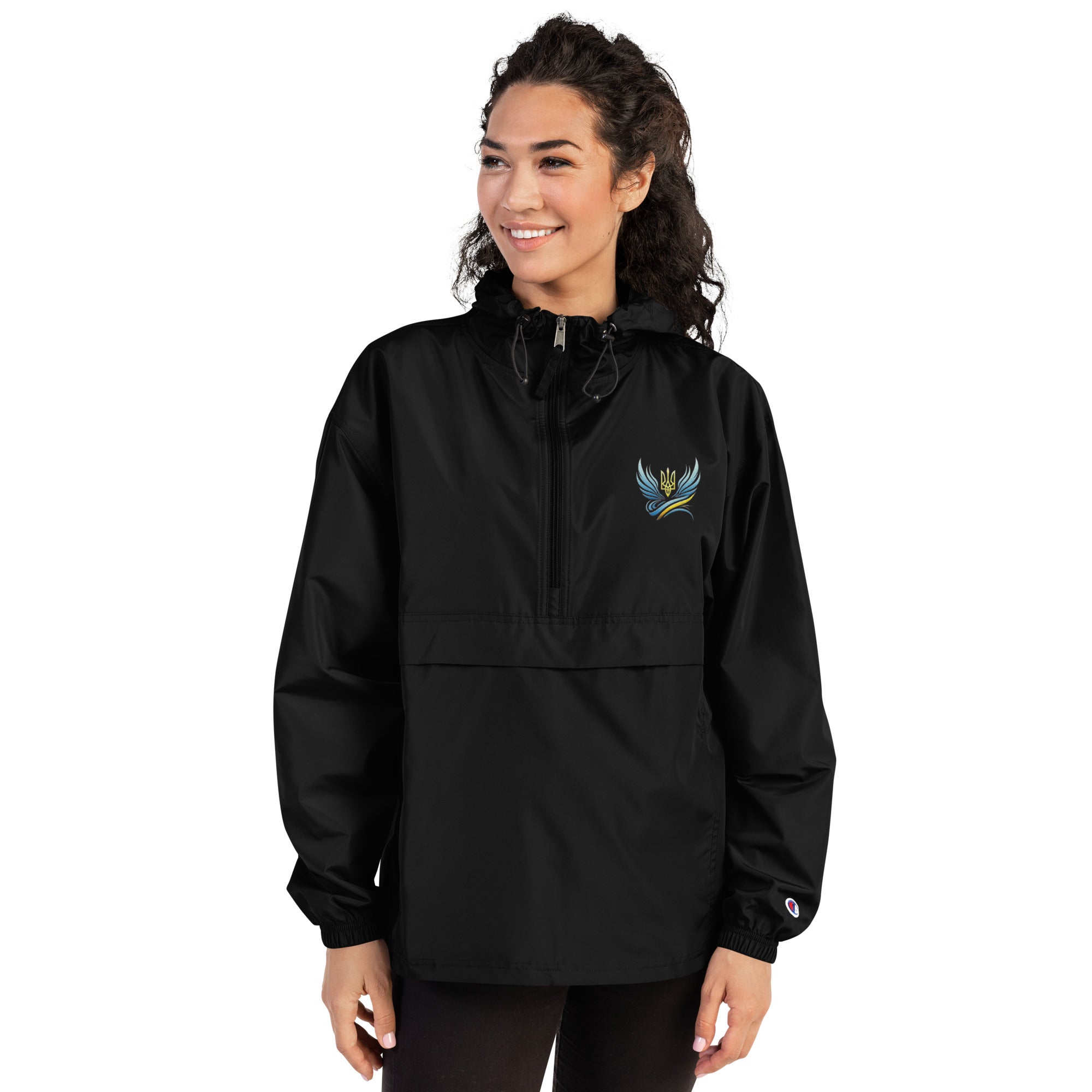 Woman wearing Ukrainian Vibe Trizub Collection embroidered Champion packable jacket, featuring a stylish design and practical hood.