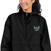 Woman wearing Ukrainian Vibe Trizub Collection embroidered Champion packable jacket, black, with hood and rain-resistant features.