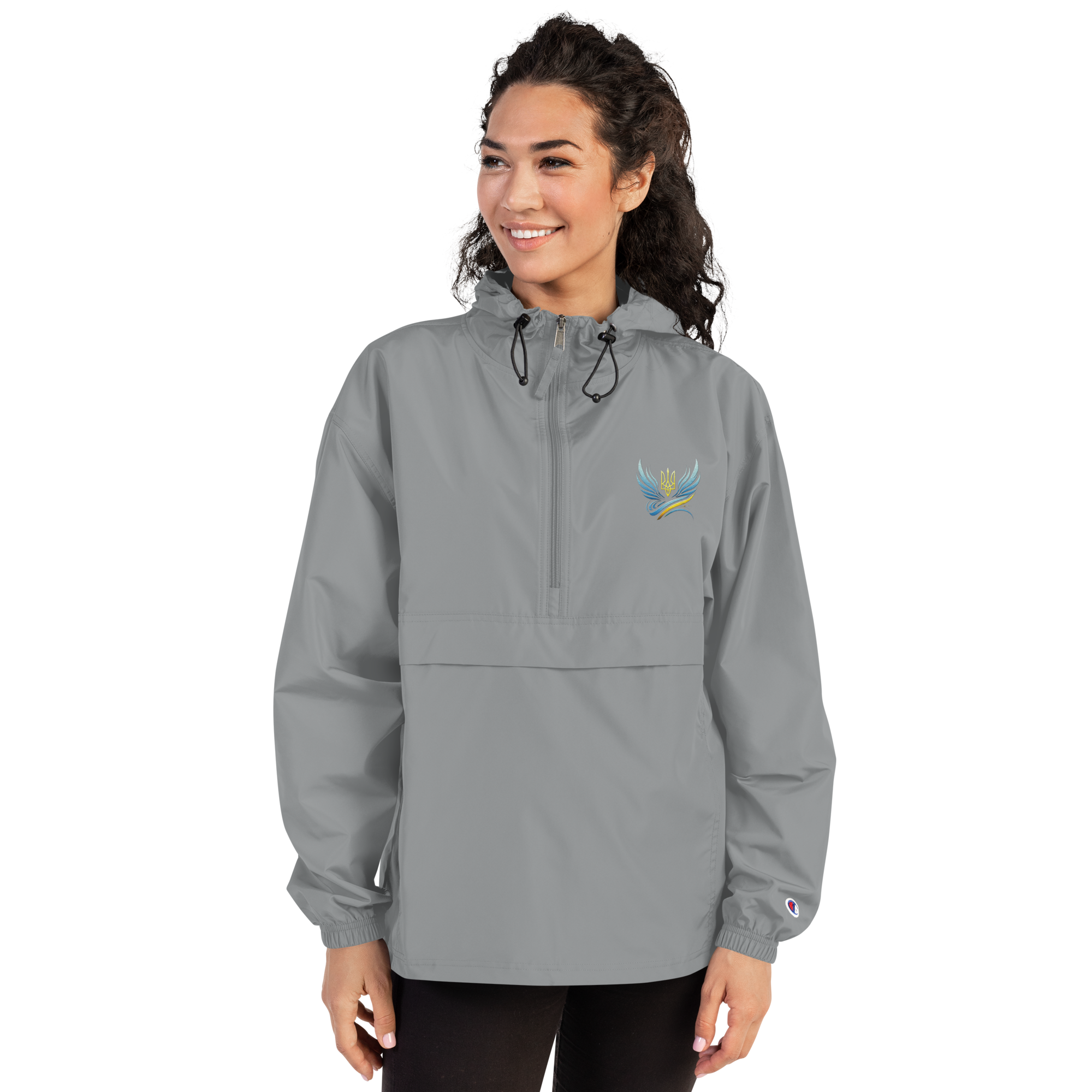 Woman wearing Ukrainian Vibe Trizub Embroidered Champion Packable Jacket, gray, with hood and kangaroo pocket.