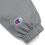 Close-up of embroidered logo on gray Champion packable jacket sleeve from Ukrainian Vibe Trizub Collection for women.
