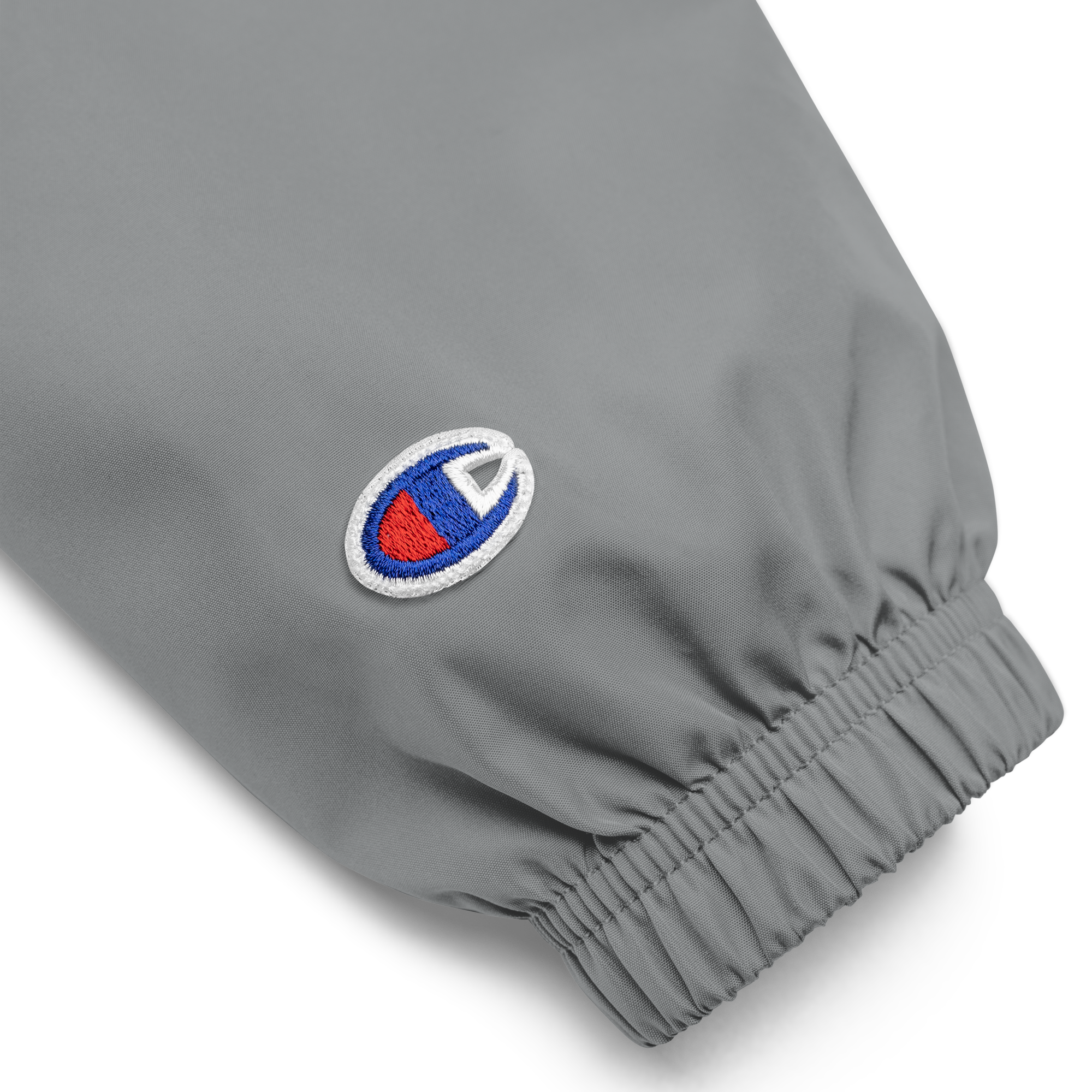 Close-up of embroidered logo on gray Champion packable jacket sleeve from Ukrainian Vibe Trizub Collection for women.