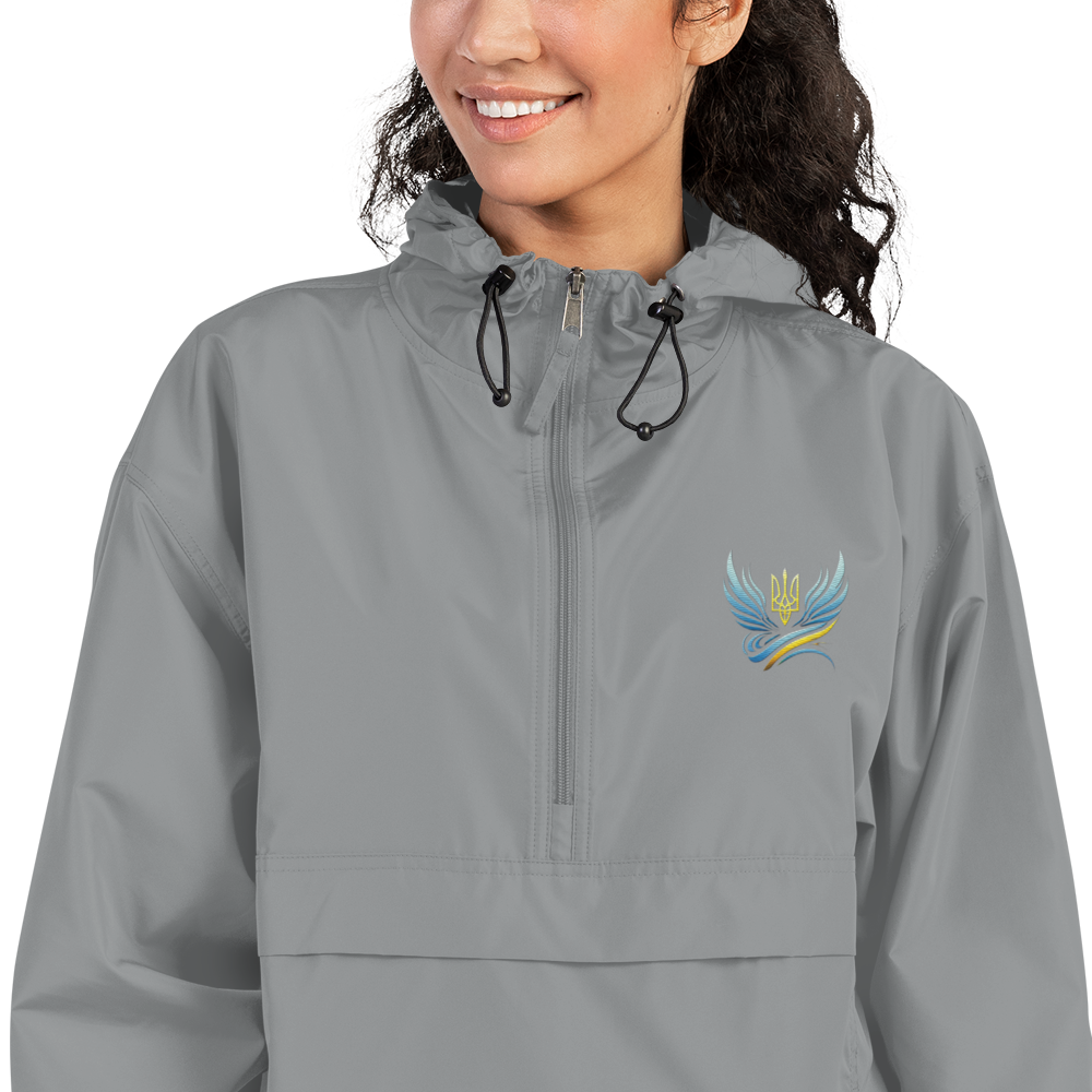 Woman wearing Ukrainian Vibe Trizub Collection embroidered Champion packable jacket, gray with Trizub symbol