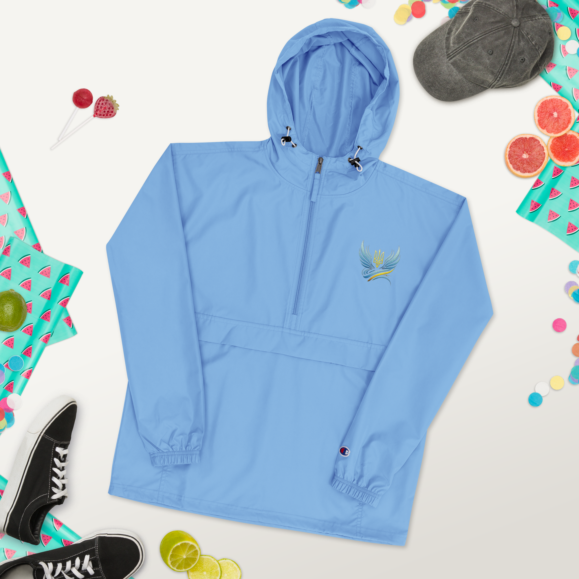 Women's embroidered blue jacket from Ukrainian Vibe Trizub Collection with hood and pockets, styled with casual accessories.