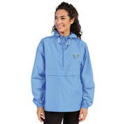 Woman wearing blue Ukrainian Vibe Trizub Collection embroidered Champion packable jacket with hood and front pockets.