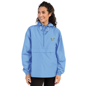 Woman wearing blue embroidered Champion packable jacket from Ukrainian Vibe Trizub Collection with hood and kangaroo pocket.