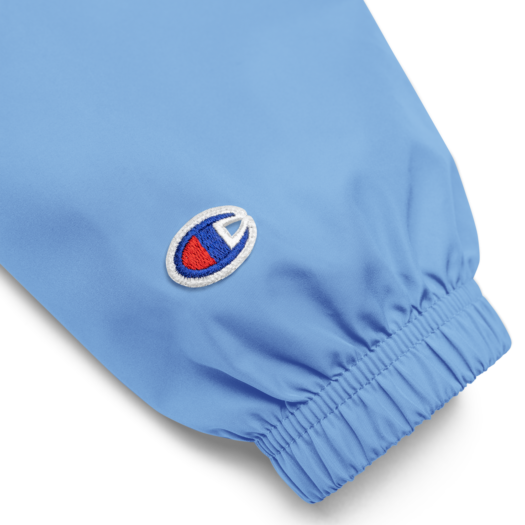 Close-up of blue Champion embroidered sleeve with elastic cuff from the Ukrainian Vibe Trizub Collection packable jacket.