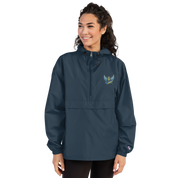 Woman wearing blue Champion packable jacket from Ukrainian Vibe Trizub Collection with embroidered Trizub design.