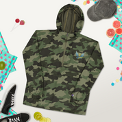 Ukrainian Vibe Trizub camo jacket for women by Champion with embroidery, rain-resistant and packable, surrounded by accessories.