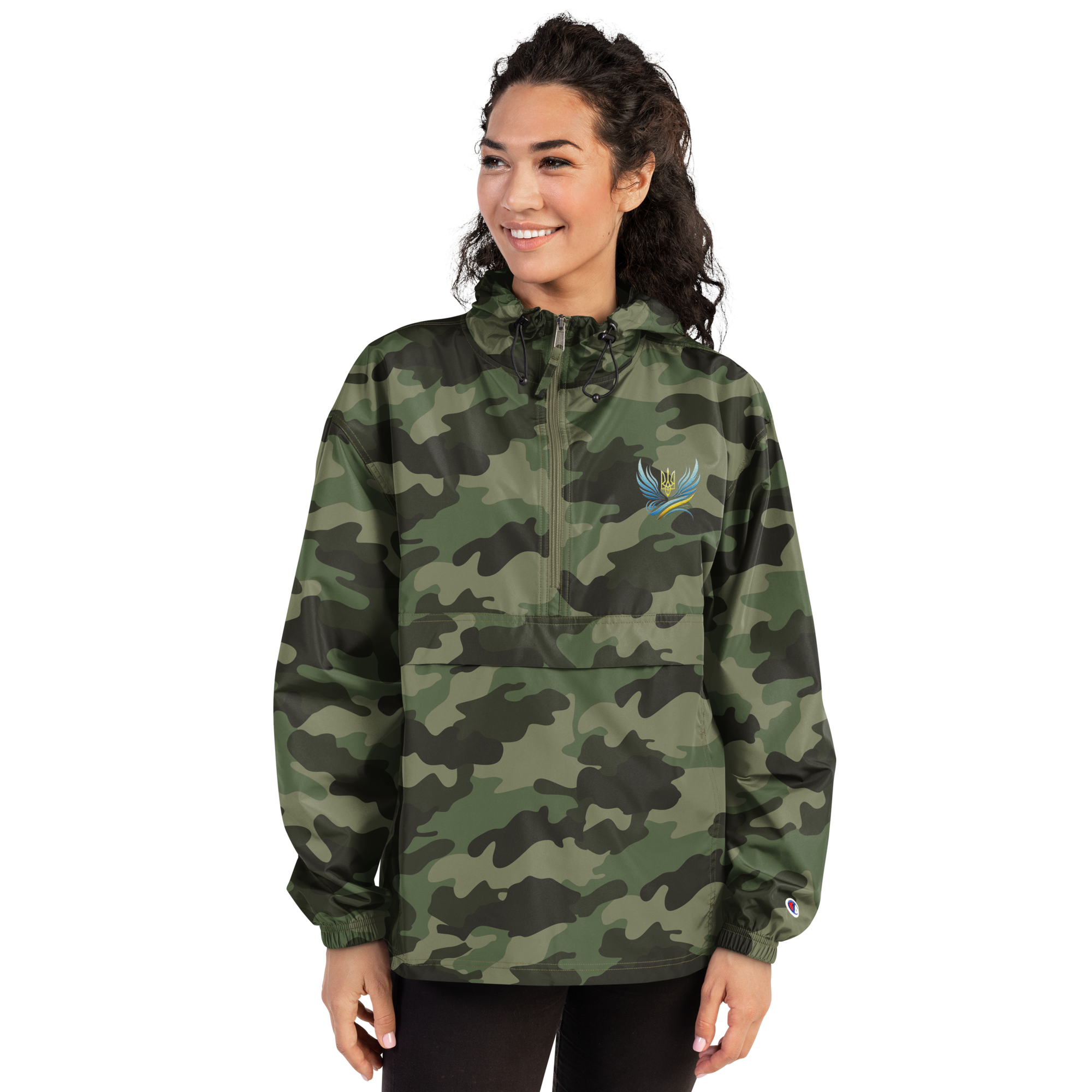 Woman wearing Ukrainian Vibe Trizub Collection embroidered camo Champion packable jacket with hood and kangaroo pocket.