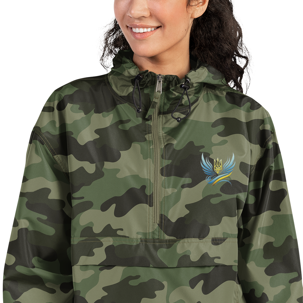 Woman wearing Ukrainian Vibe Trizub Collection camo jacket with embroidery, Champion packable style, perfect for wind and rain protection.